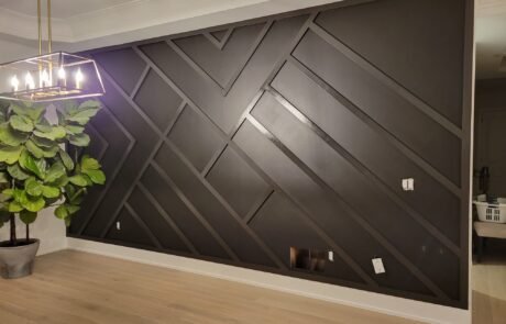 Full wall accent wainscoting installation in a modern Toronto condo living room, creating depth and a dramatic feature wall behind the sofa.