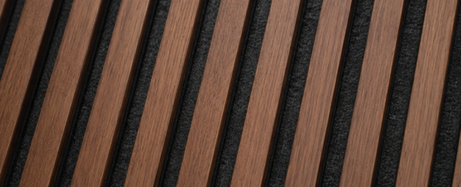 Close-up of modern walnut acoustic slat wall panels with black felt backing and natural wood grain texture.